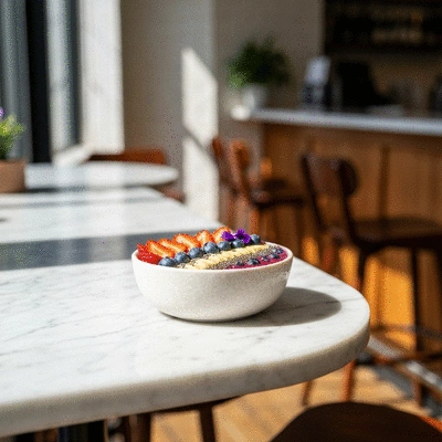 Vibrant colorful smoothie bowl with fresh berries, nuts, and edible flowers on a cafe table