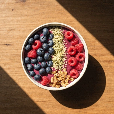 Vibrant colorful smoothie bowl with fresh berries and granola on a wooden table