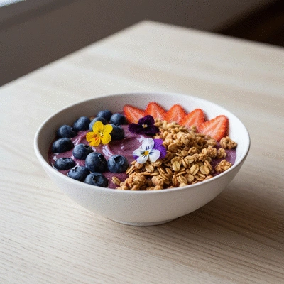 Colorful acai bowl topped with fresh berries, chia seeds, and edible flowers